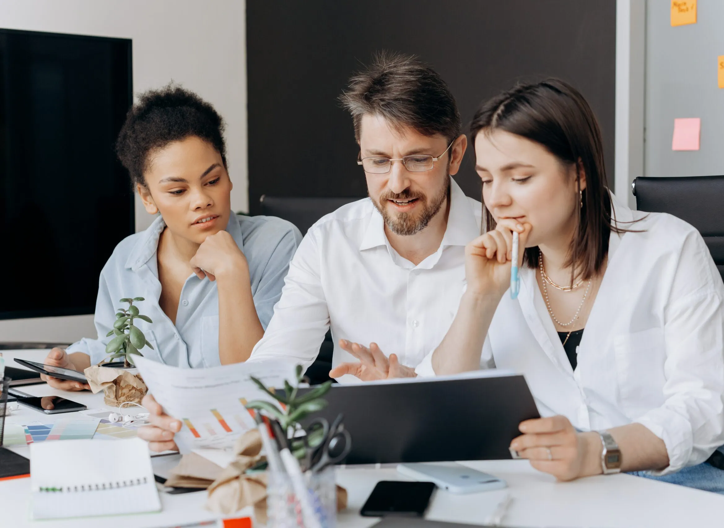 Three colleagues collaborate on a project, sharing ideas and working towards a common goal