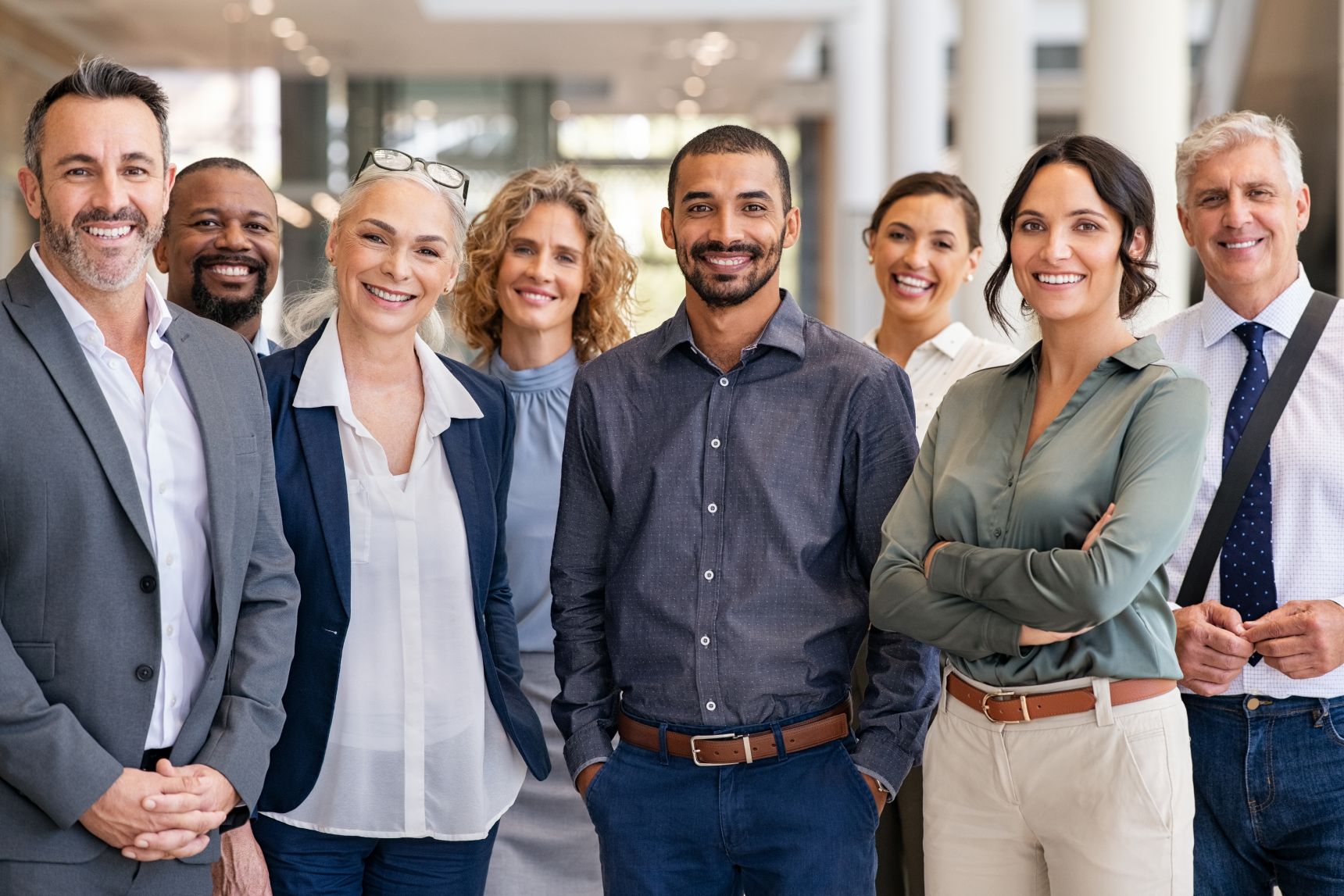 A group of individuals from various cultural and ethnic backgrounds poses for a photo